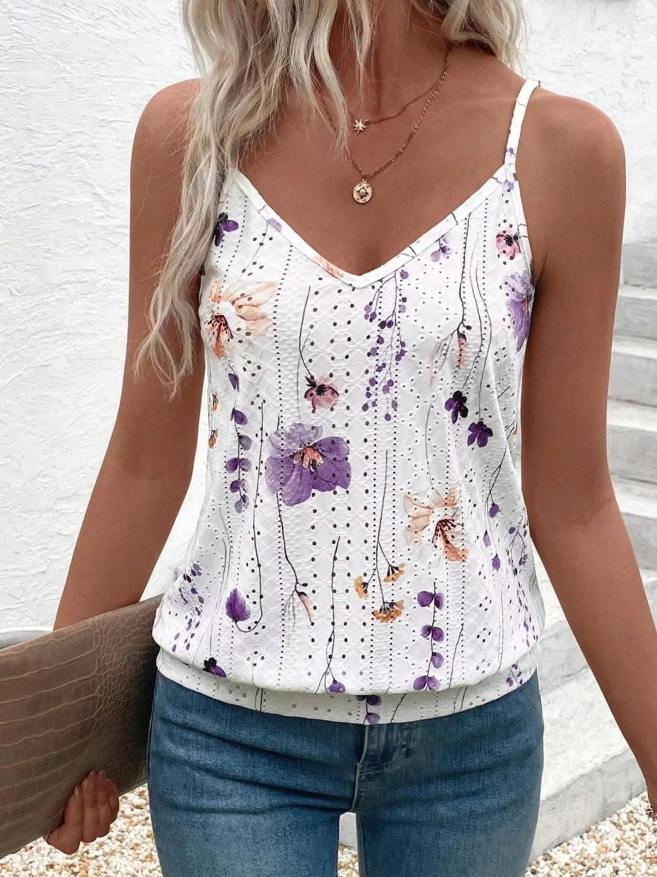 Woman wearing a floral print tank top with a white background
