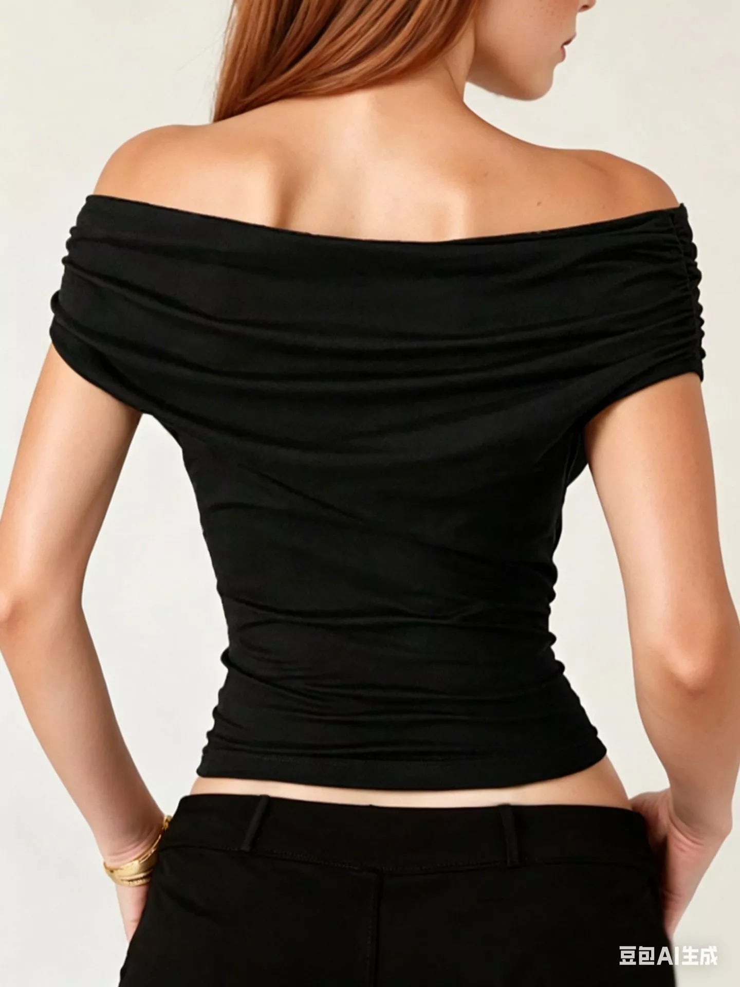 Black off-shoulder top worn by a person on a plain background