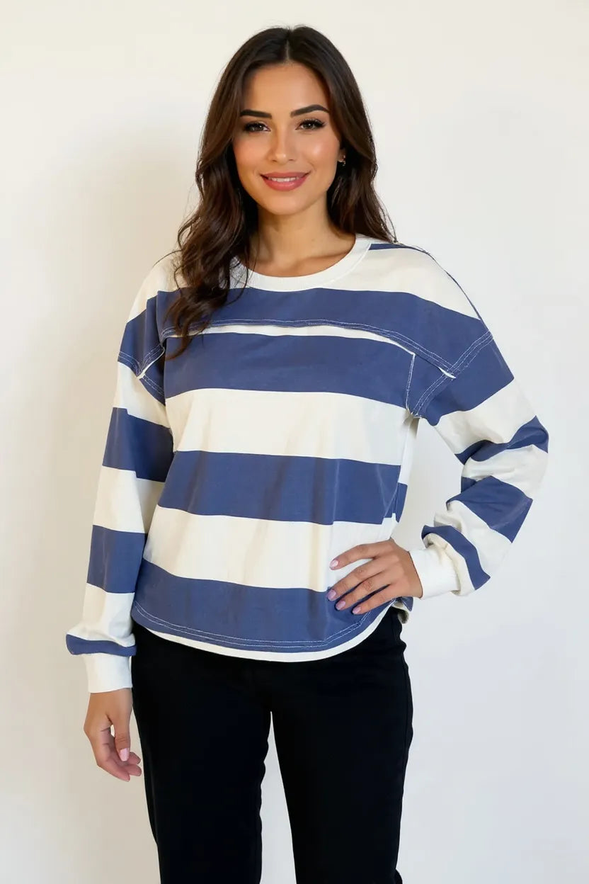 Woman wearing a blue and white striped sweater against a plain background