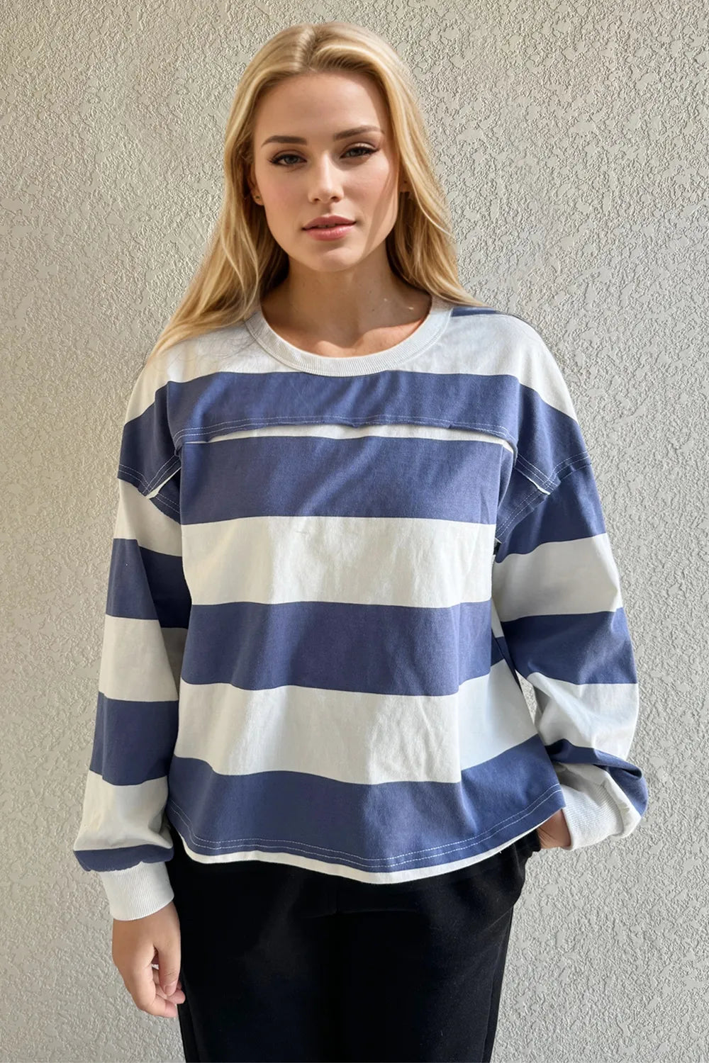 Woman wearing a blue and white striped sweater against a plain background