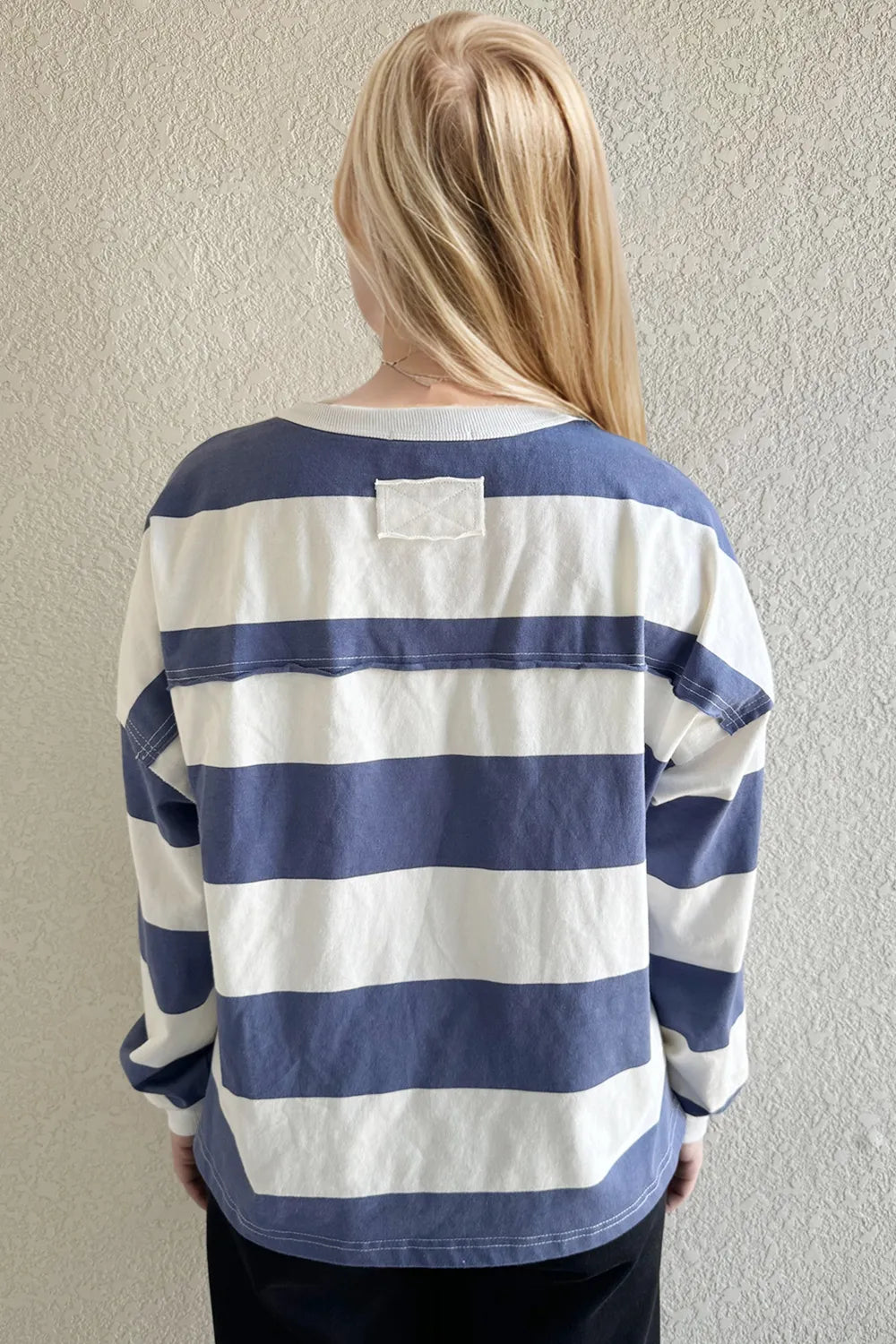 Person wearing a blue and white striped shirt against a plain background