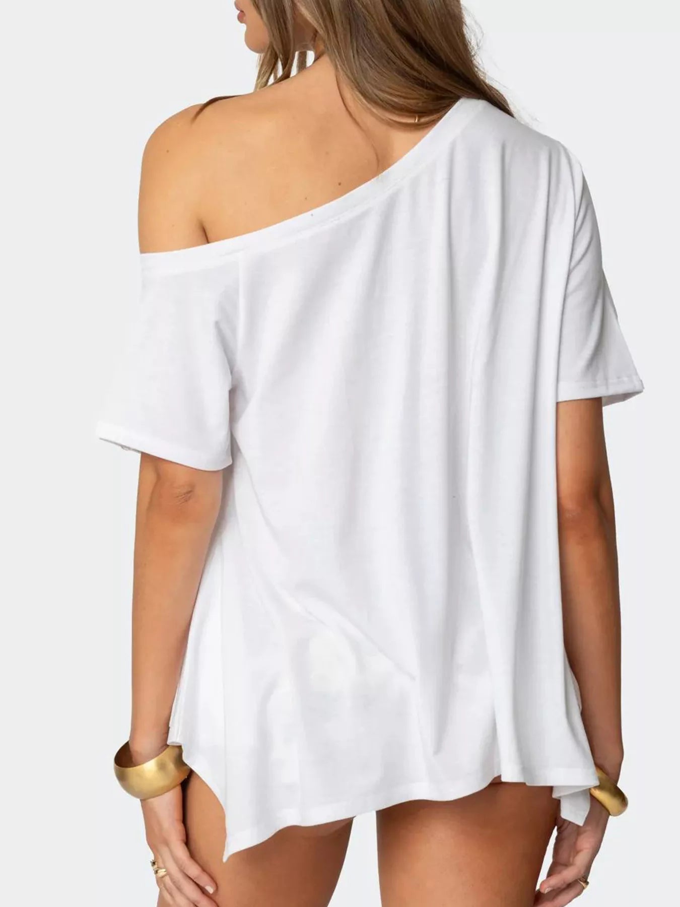 White off-shoulder top worn by a person on a white background