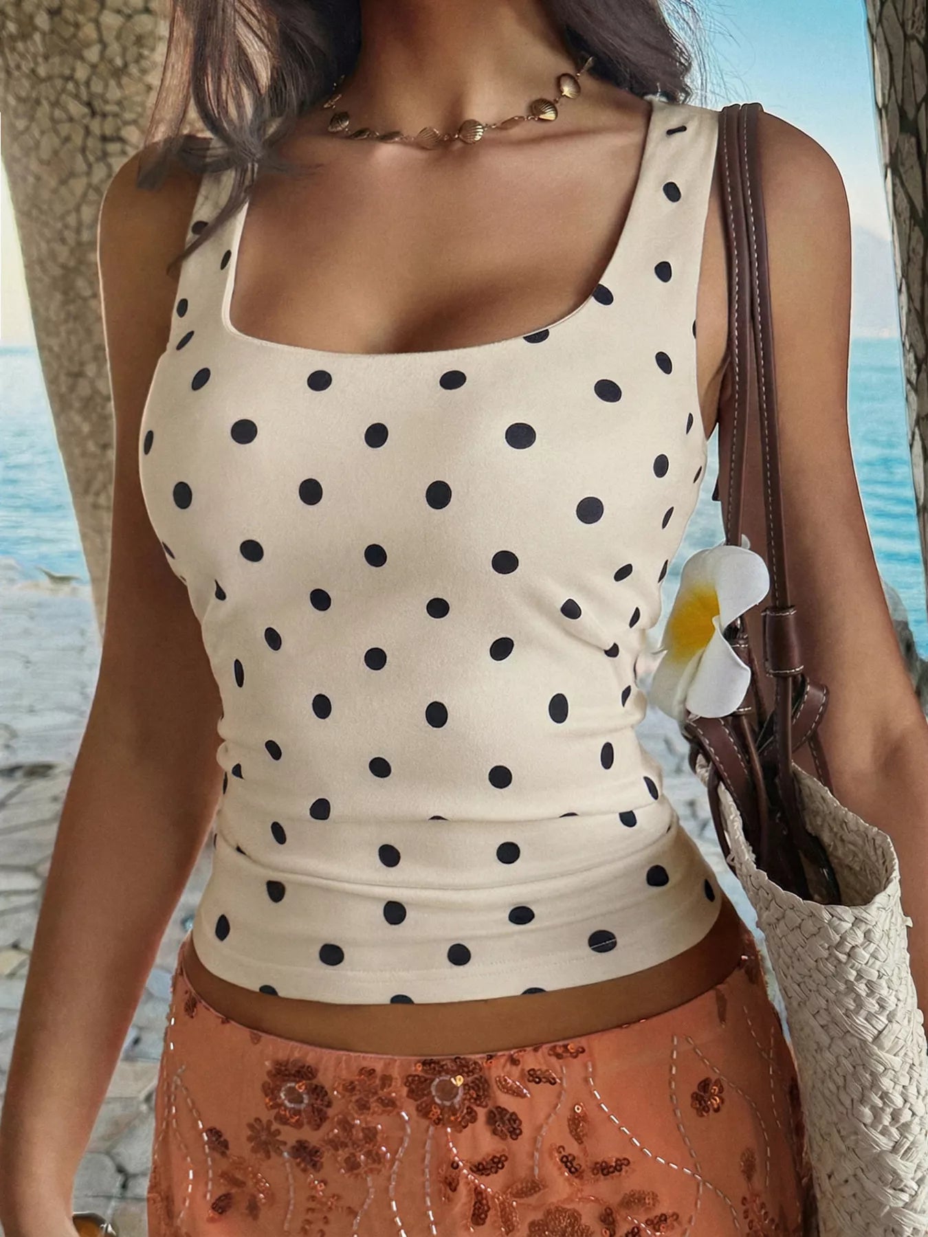 Woman wearing a polka dot top with a beach background