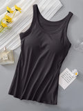 Black tank top on a gray surface with yellow flowers and a glass of water in the background.