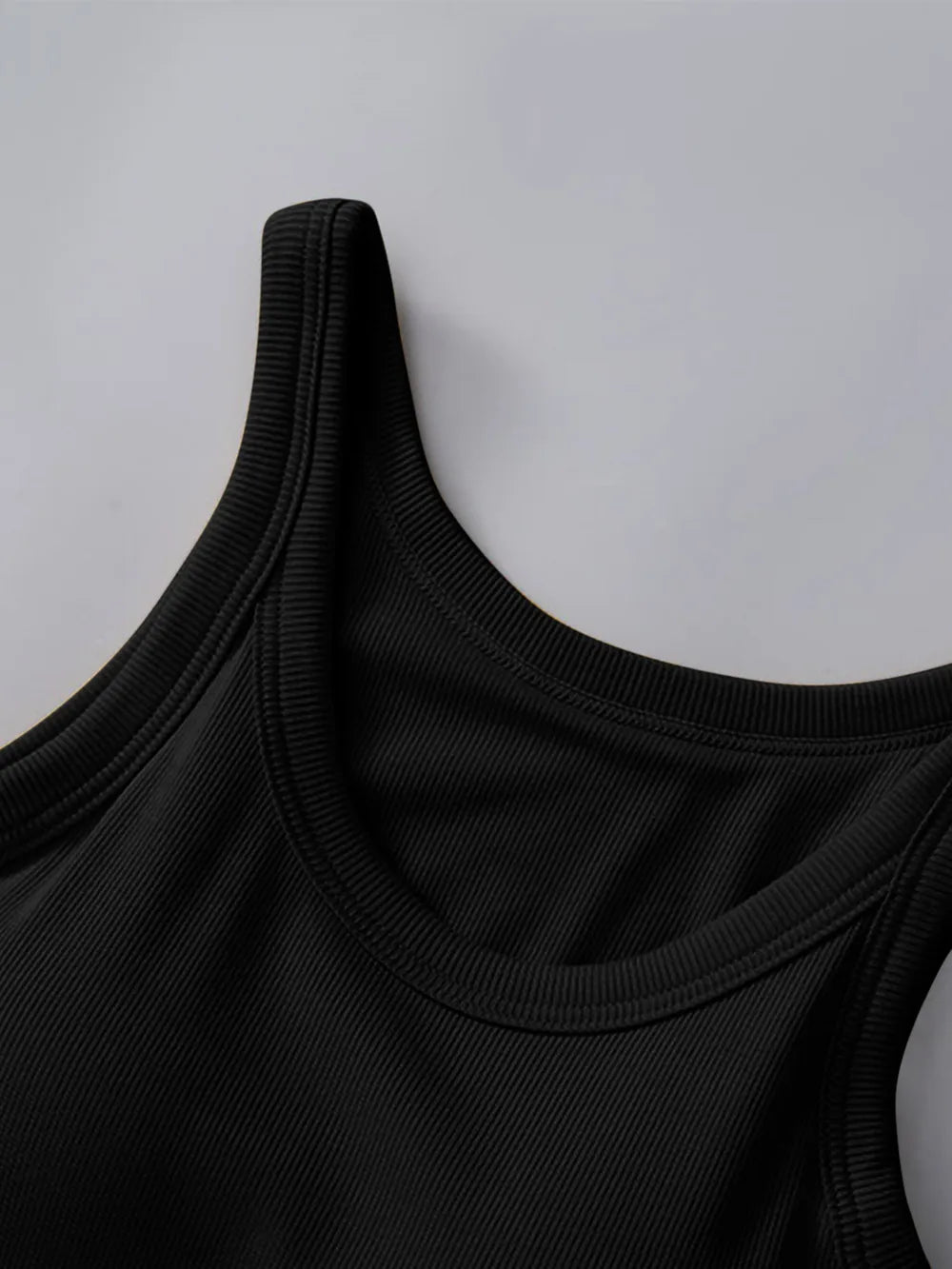 Close-up of a black tank top on a light gray background