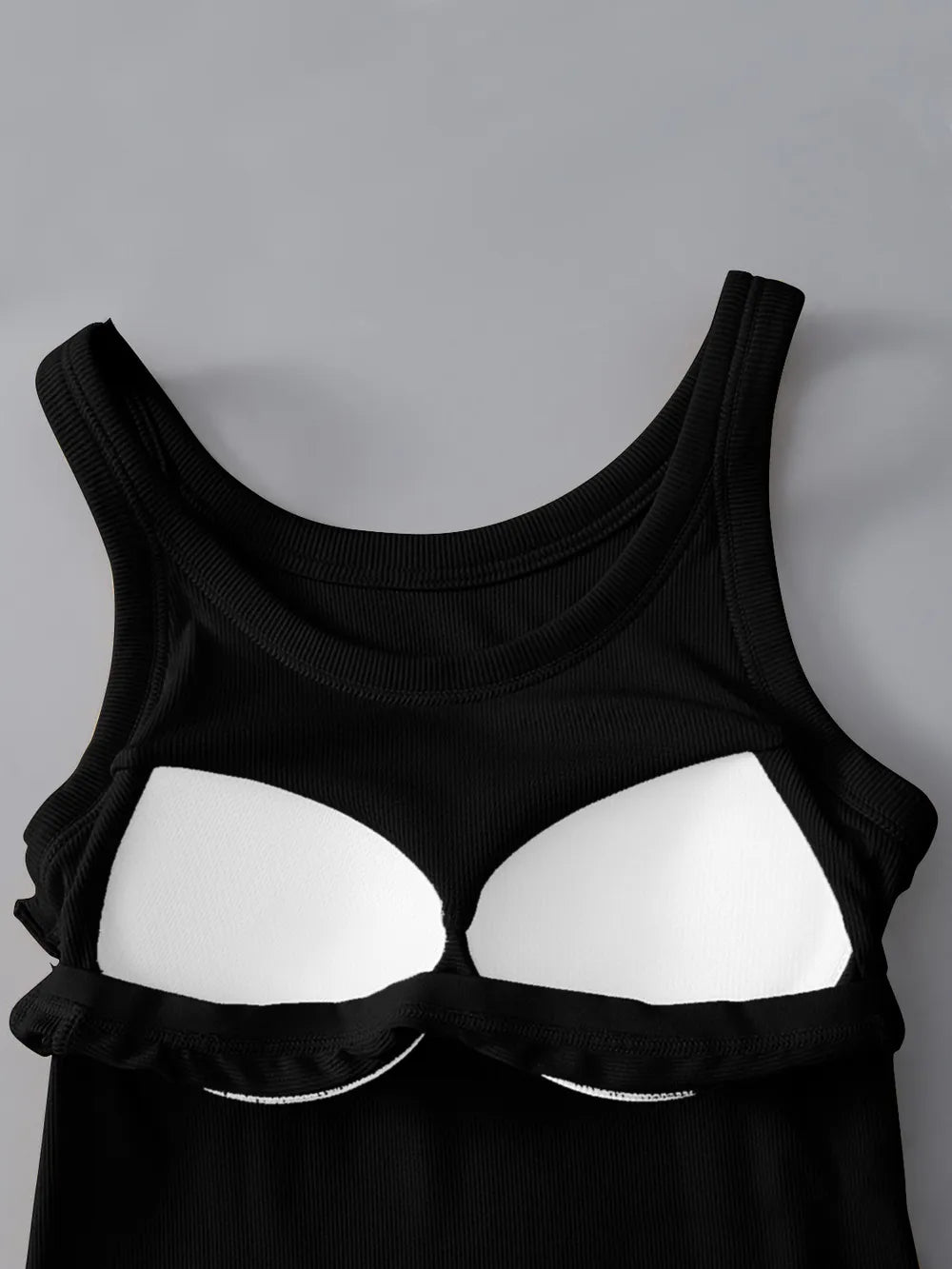 Black tank top with reflective white panels on a gray background