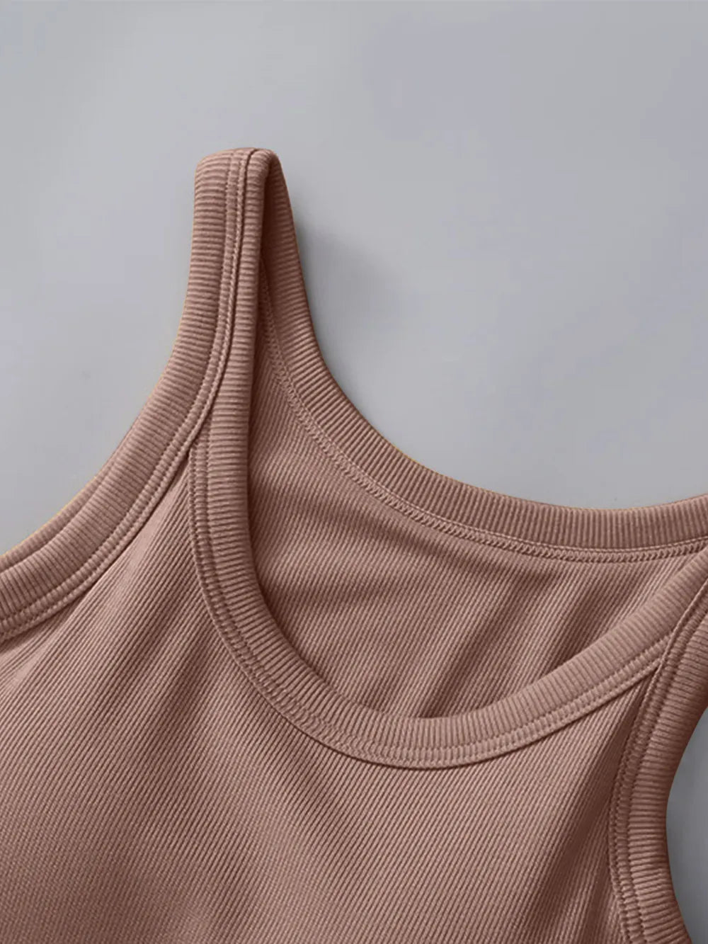 Close-up of a pink tank top against a gray background