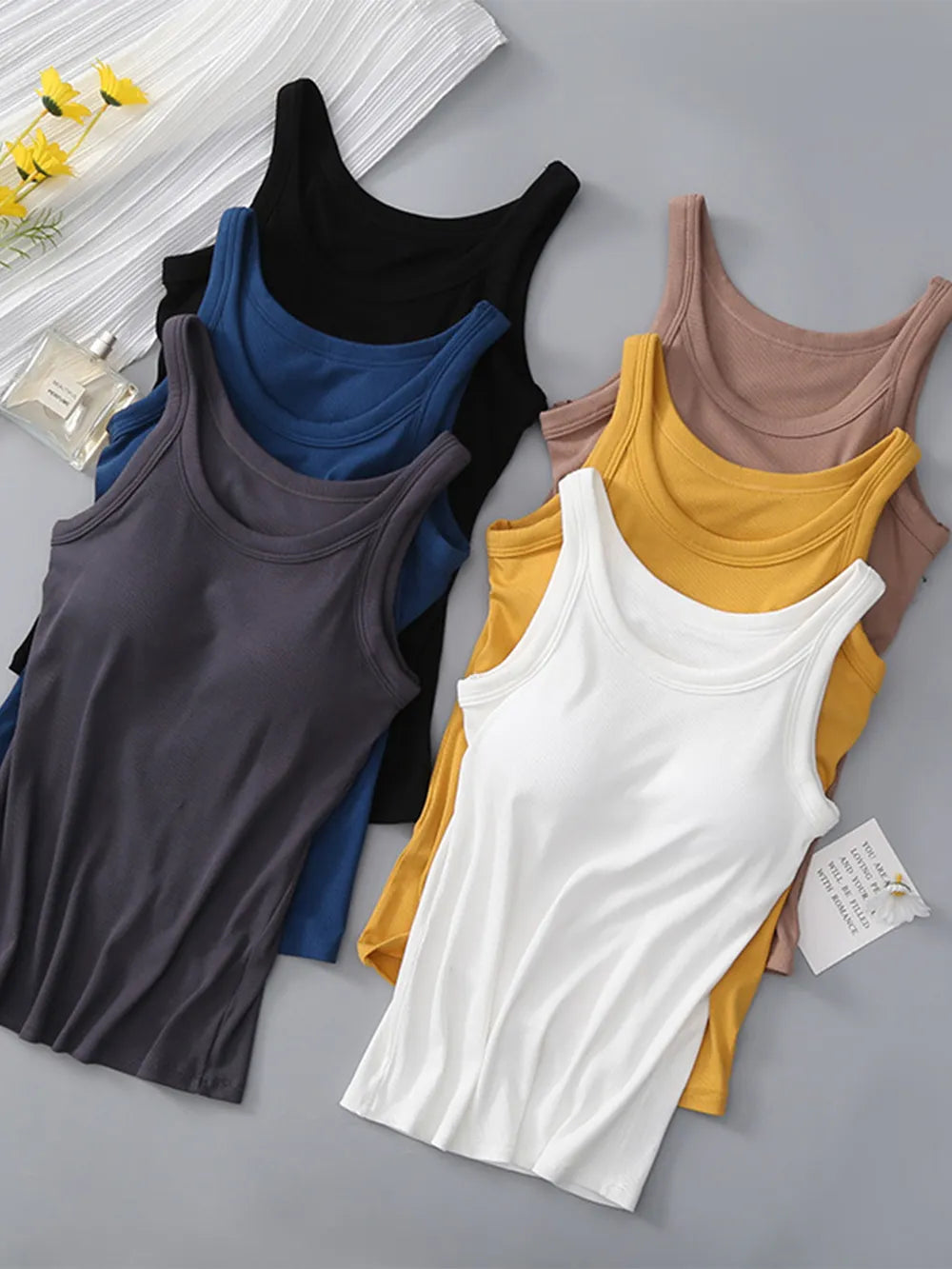 Collection of colorful tank tops on a gray surface
