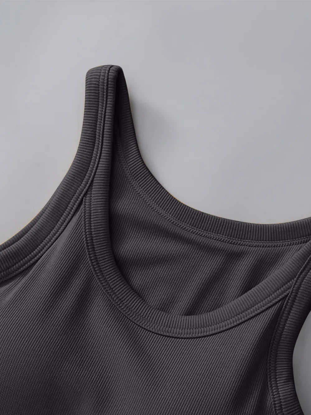 Close-up of a dark gray tank top on a light gray background