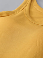 Close-up of a mustard yellow sleeveless top with a gray background
