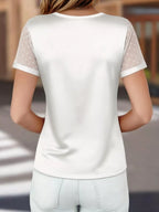 White t-shirt with sheer sleeves worn by a person, blurred background
