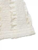 Close-up of a textured white fabric with cable knit pattern