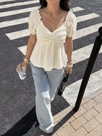 Person wearing a white blouse and light blue jeans on a crosswalk