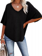 Person wearing a black oversized t-shirt and blue jeans on a white background