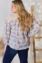 Woman wearing a floral blouse with long sleeves in a home setting.