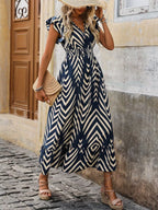Woman wearing a blue and white patterned dress on a street.