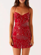 Red dress with floral patterns and embellishments on a white background