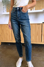 Person wearing blue jeans and white sneakers in an indoor setting