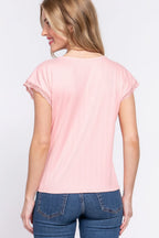 Woman wearing a pink top with lace sleeves and blue jeans on a white background