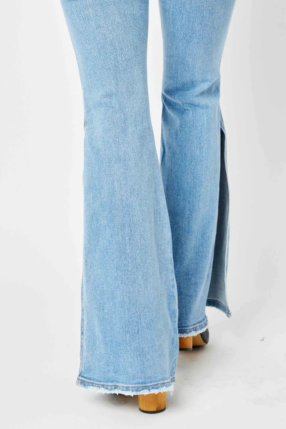 Light blue flared jeans with a slit on a white background