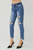Blue distressed jeans worn by a person on a gray background