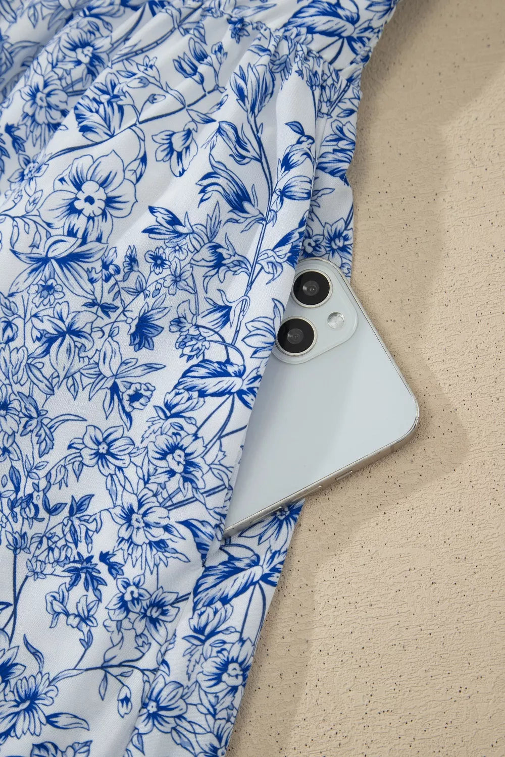 White phone with blue floral pattern on fabric