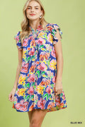 Woman wearing a colorful floral dress on a green background