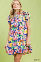 Woman wearing a colorful floral dress on a green background