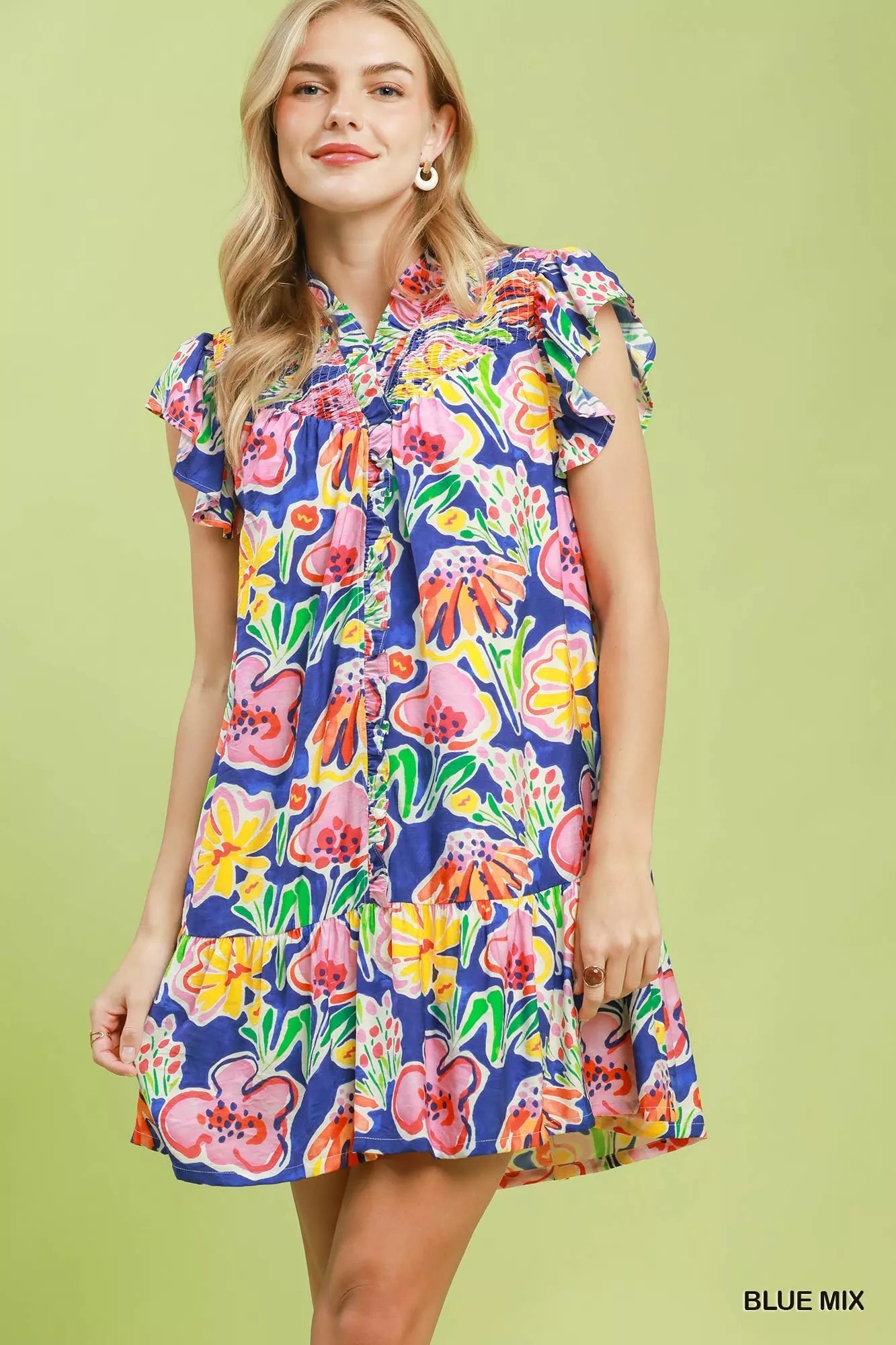 Woman wearing a colorful floral dress on a green background