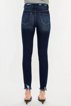 Dark blue jeans worn by a person on a white background