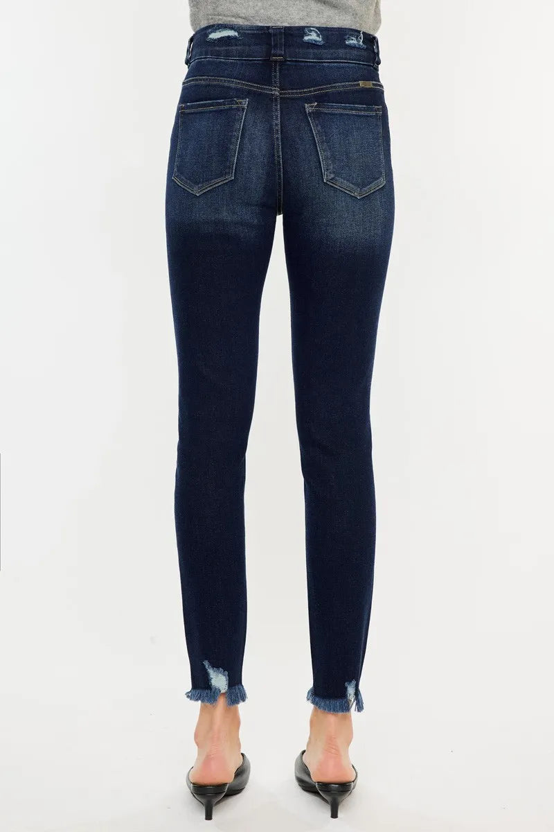 Dark blue jeans worn by a person on a white background