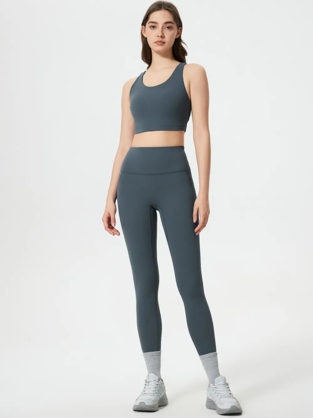 Woman wearing a gray athletic outfit on a white background