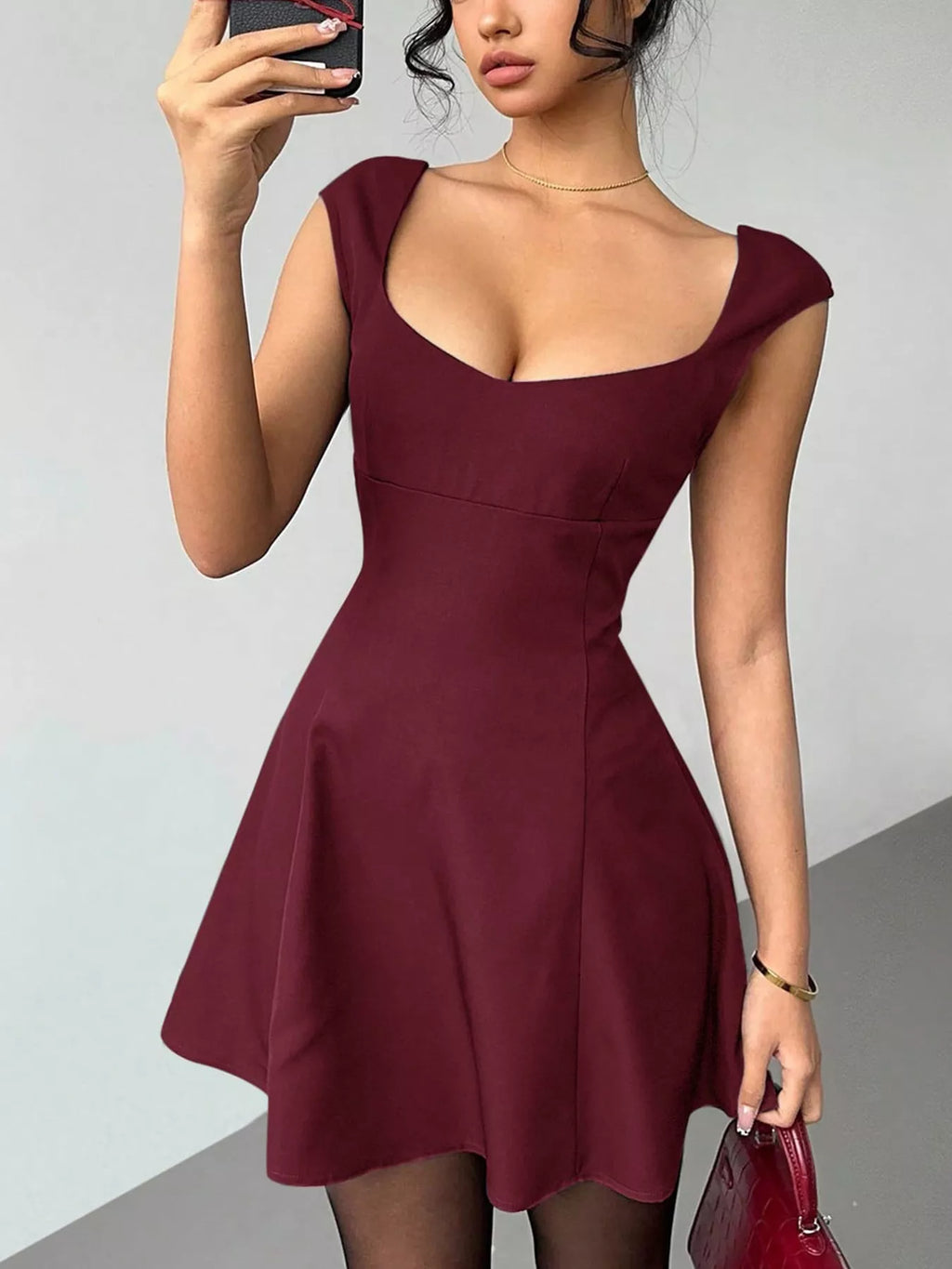 Woman wearing a burgundy dress against a plain background