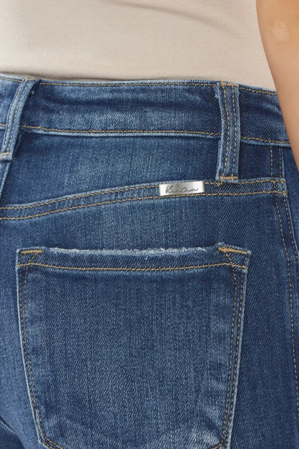 Close-up of blue jeans with a brand label on the back pocket.