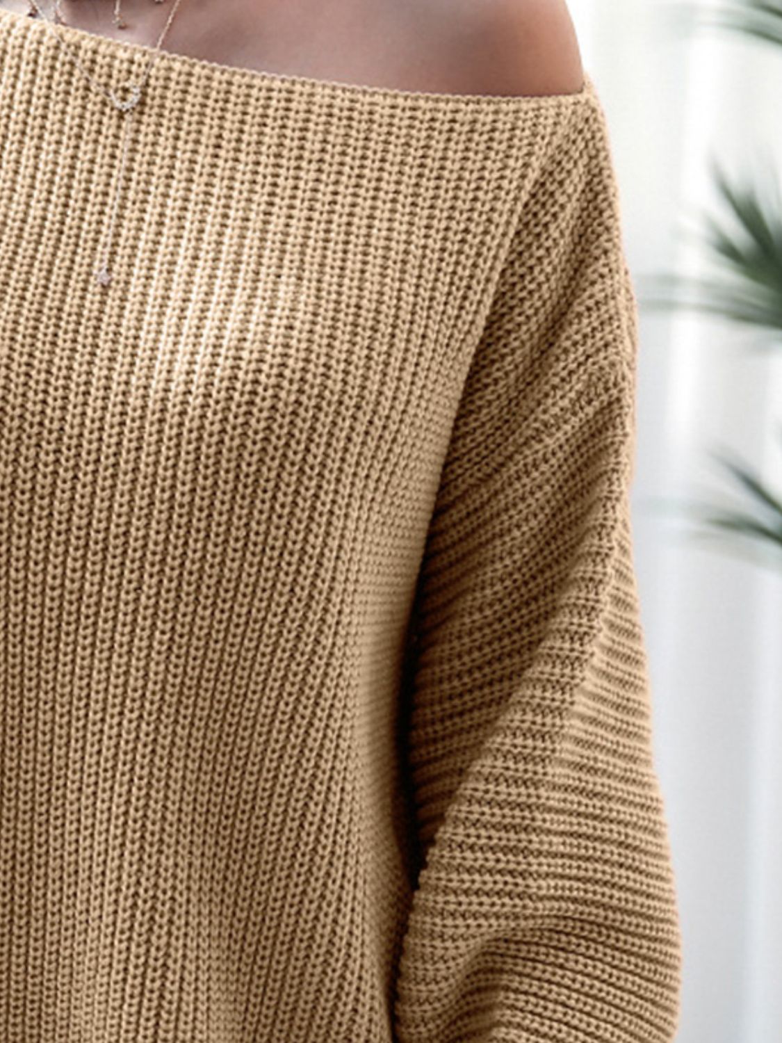 Close-up of a brown knitted sweater with a blurred background