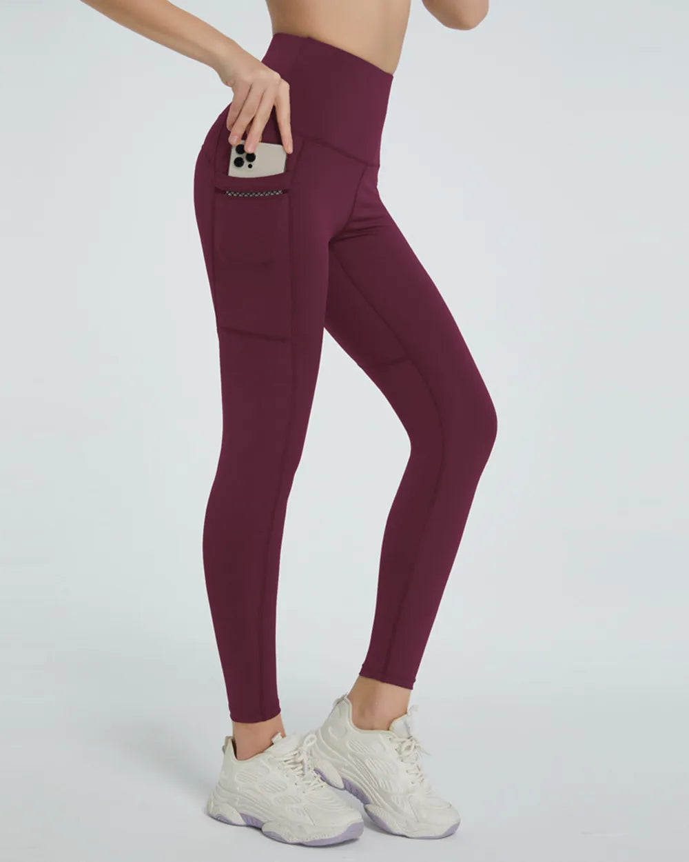 Maroon leggings worn by a person on a white background