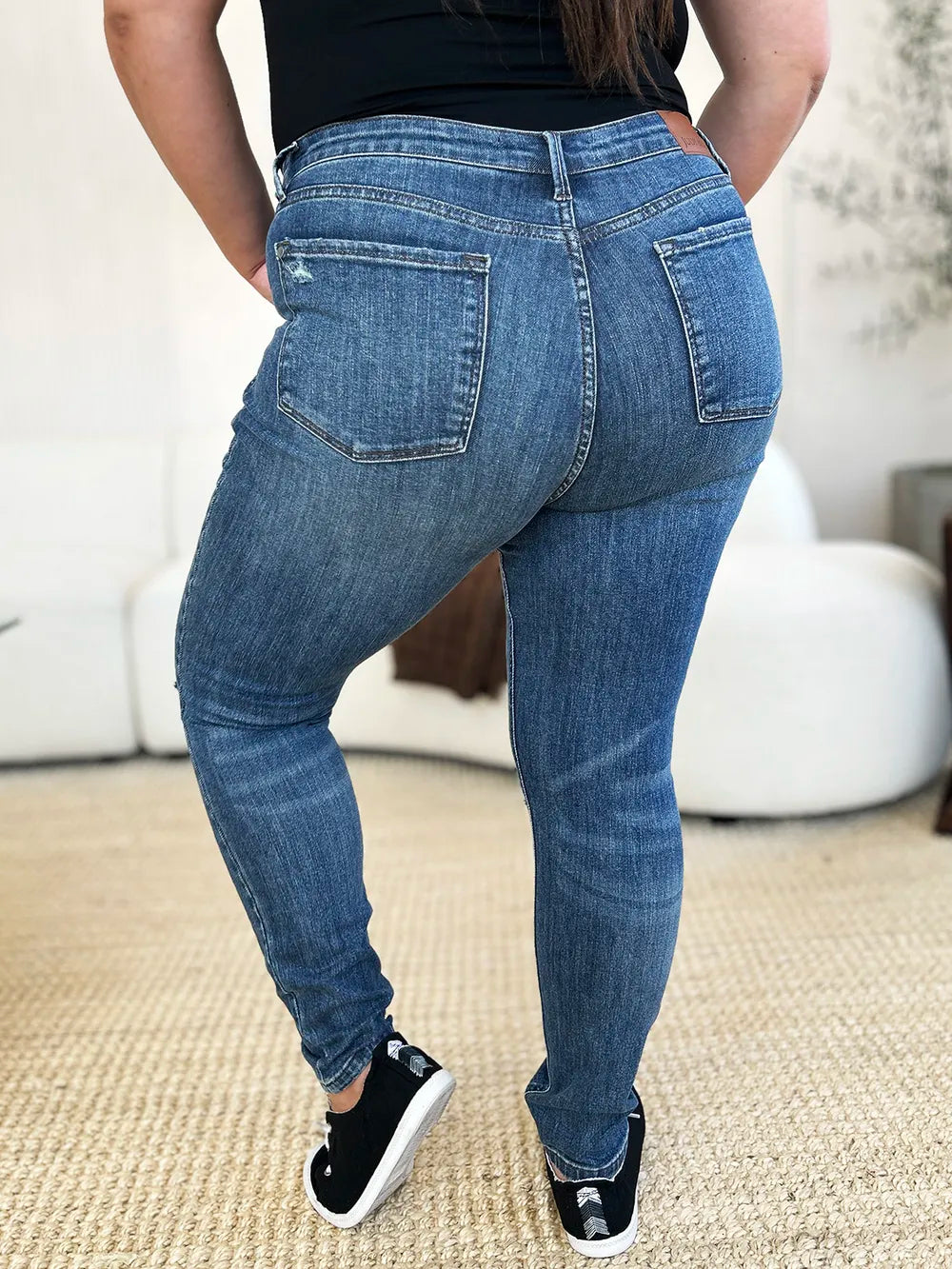 Person wearing blue jeans with a neutral background