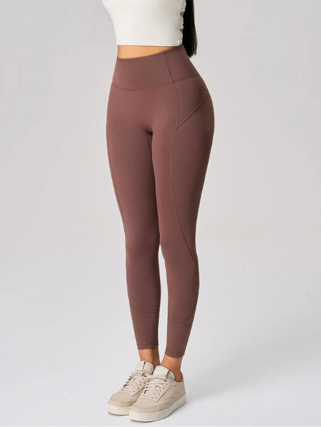 Brown leggings worn by a person on a white background