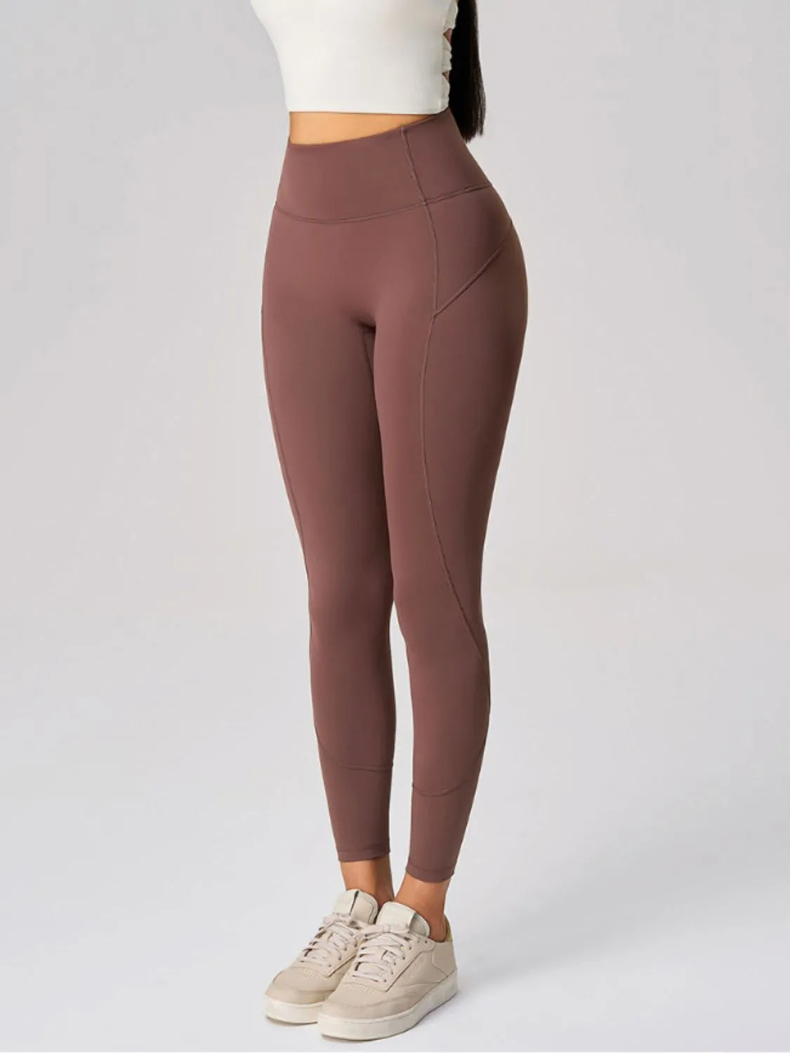 Brown leggings worn by a person on a white background