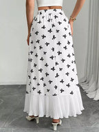 White skirt with black floral pattern worn by a person on a neutral background
