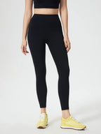 Person wearing black leggings and yellow sneakers on a white background