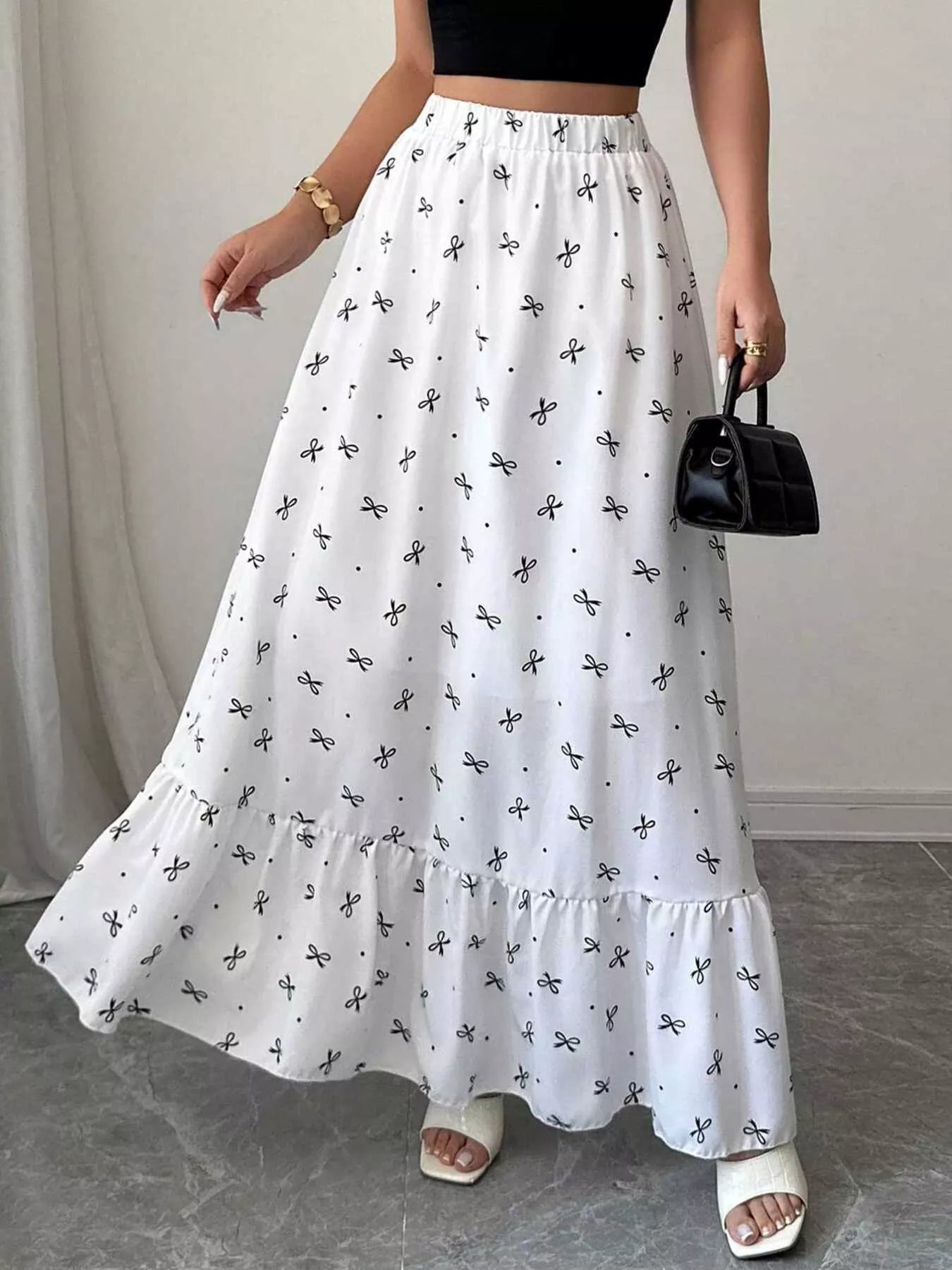Person wearing a white floral skirt with a plain background