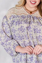 Woman wearing a floral dress with long sleeves on a plain background