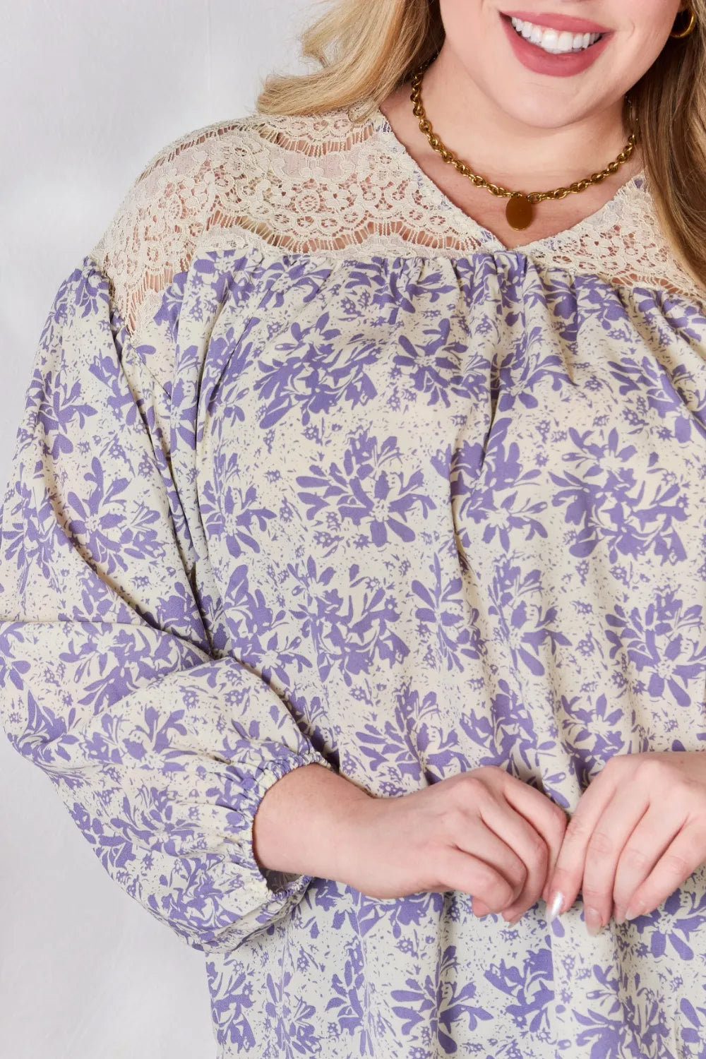 Woman wearing a floral dress with long sleeves on a plain background