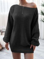 Person wearing a black off-shoulder sweater in a neutral indoor setting