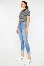 Woman wearing a striped shirt and light blue jeans on a white background