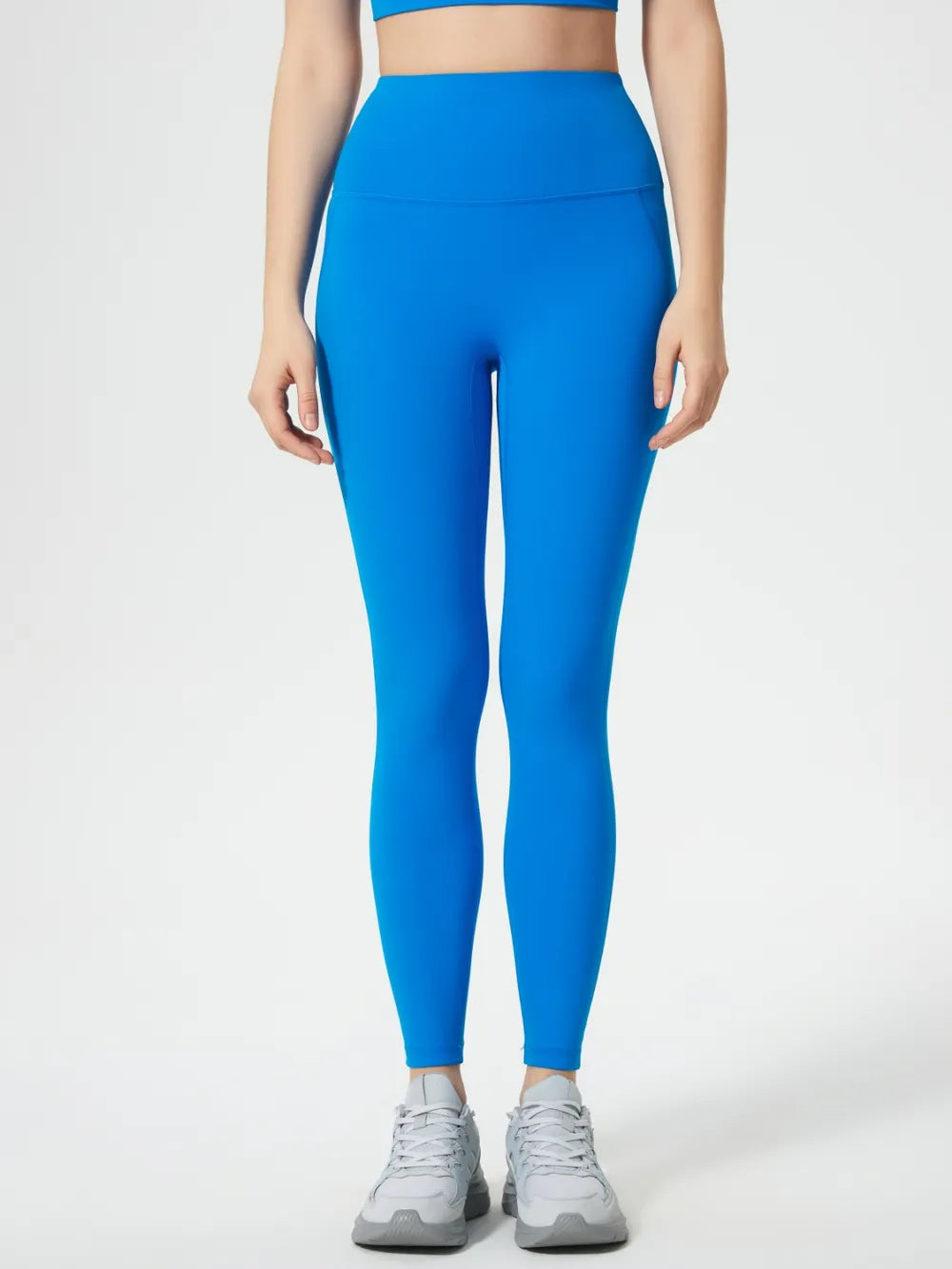 Person wearing bright blue leggings on a white background
