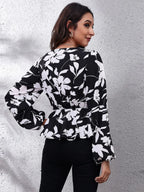 Woman wearing a black floral blouse against a gray background