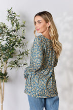 Woman wearing a floral blouse with a plant on a white background