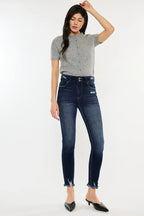 Woman wearing a gray top and dark blue jeans on a white background